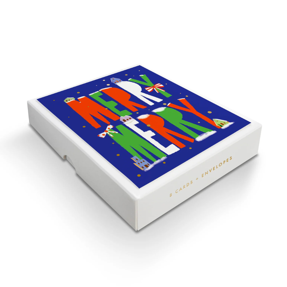 Box of greeting cards with colorful Christmas designs on a white background