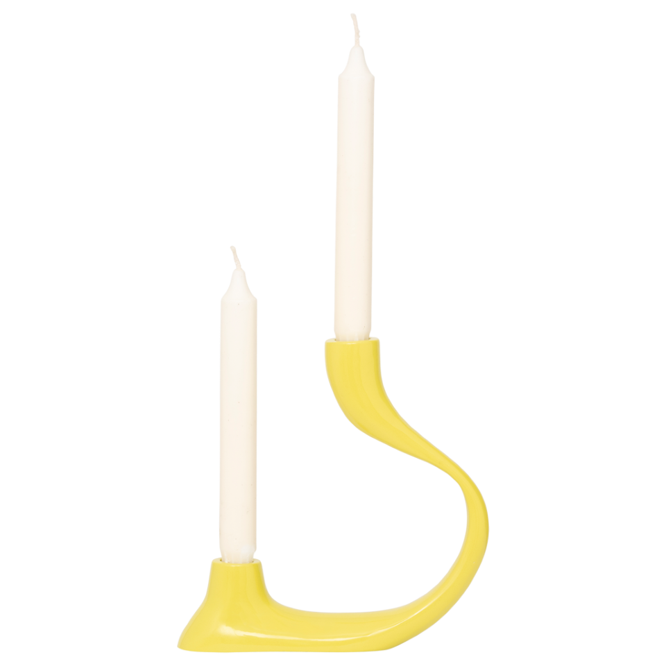 Yellow candle holder with two white candles on a white background