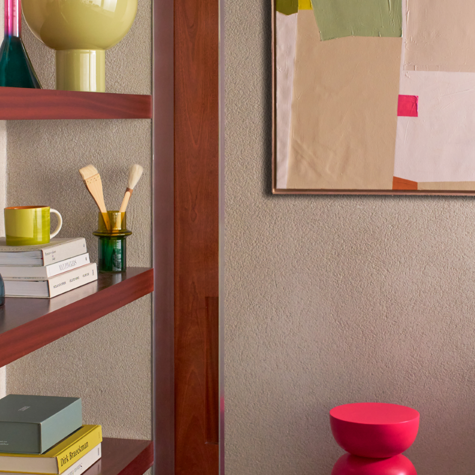 Decorative interior with a shelf, books, and a colorful abstract painting on a wall.