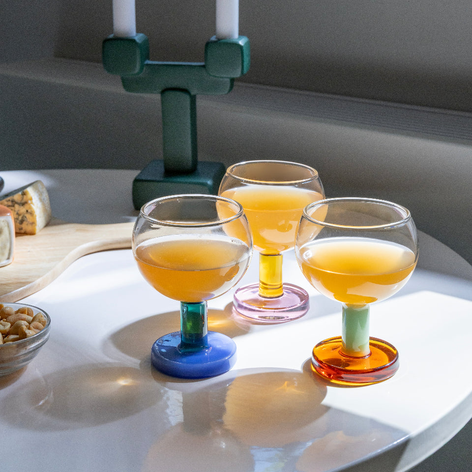 Colorful glassware on a white surface with a neutral background