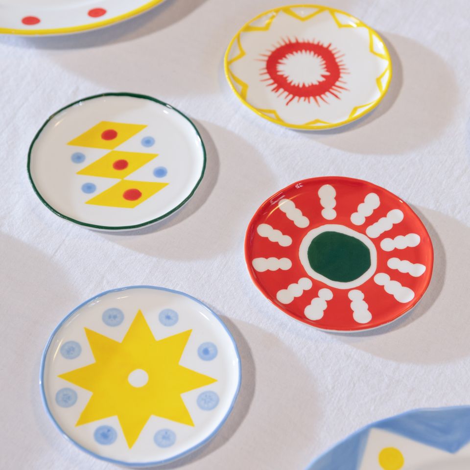 Set of colorful ceramic plates with abstract designs on a white surface.