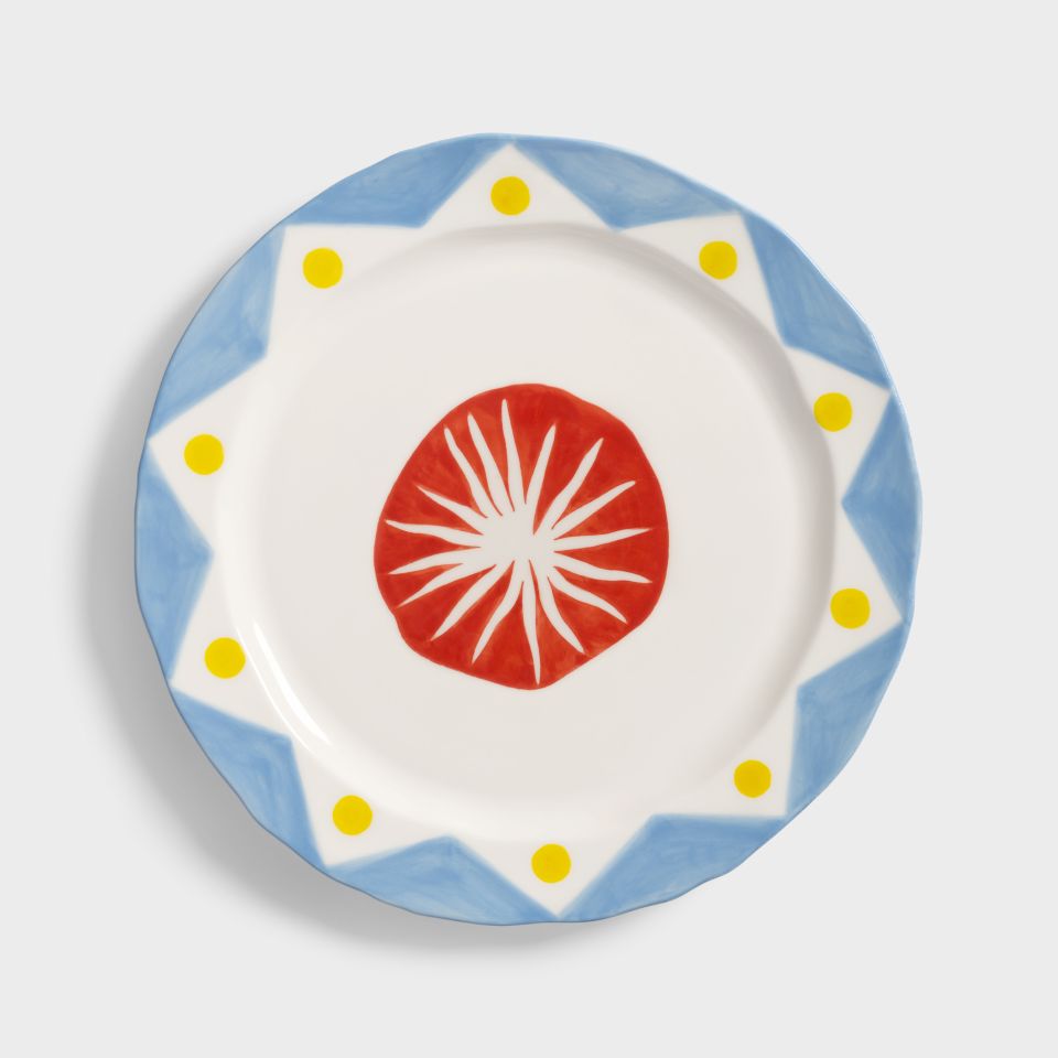 Serving plate with blue rim and modern red star in the centre on a white background