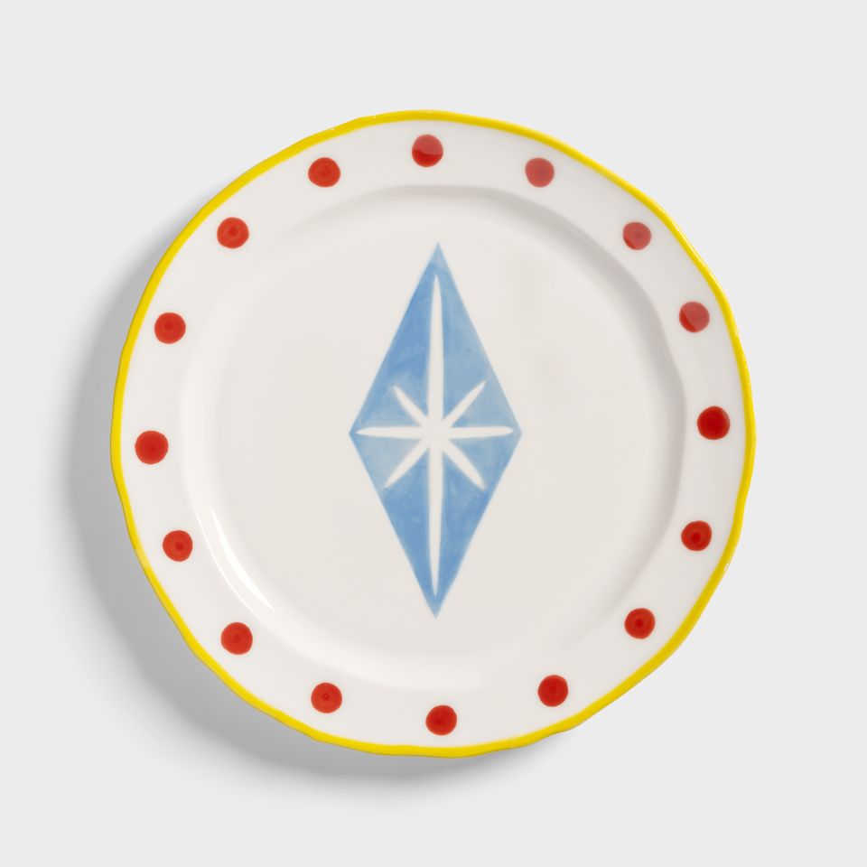 Decorative plate with a blue diamond design and red polka dots on a white background