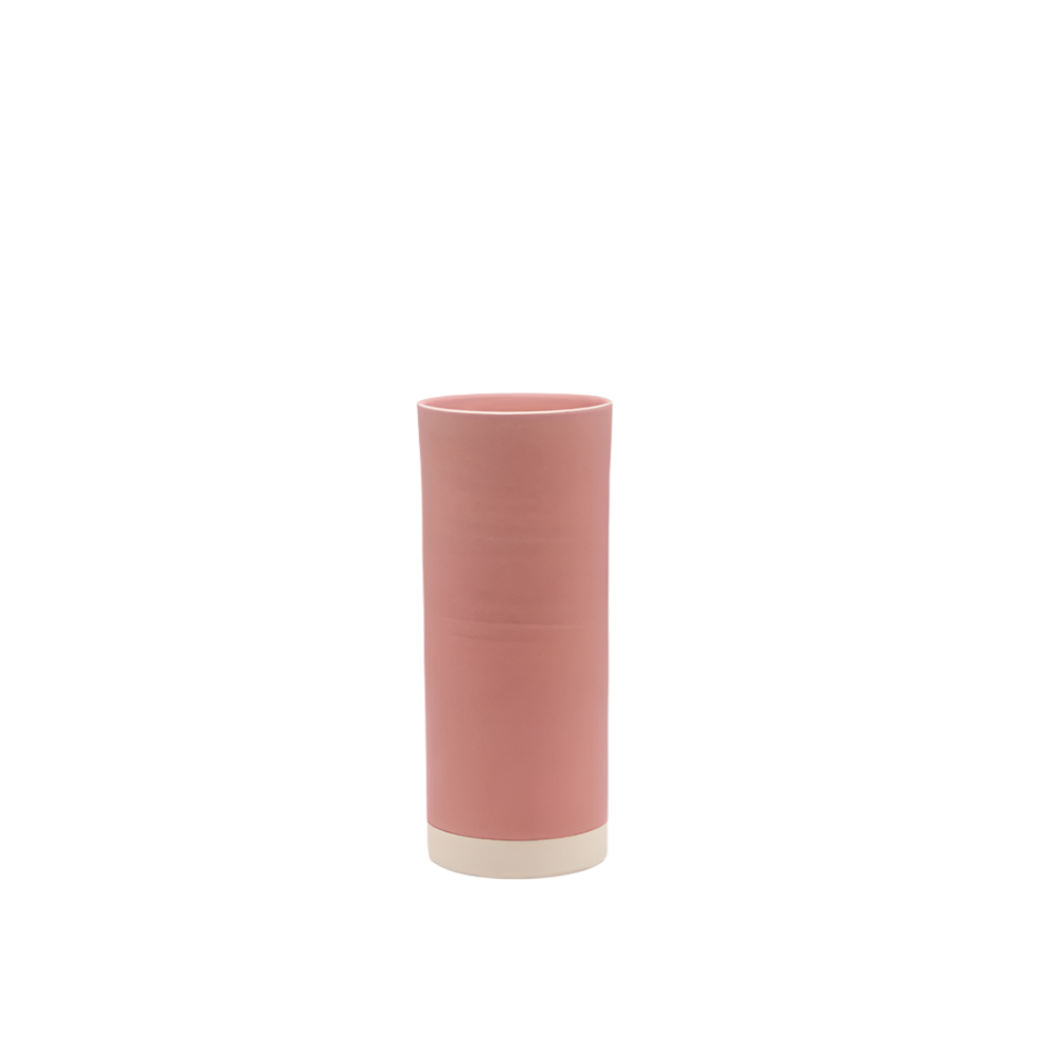 Pink cylindrical vase with a white base on a white background