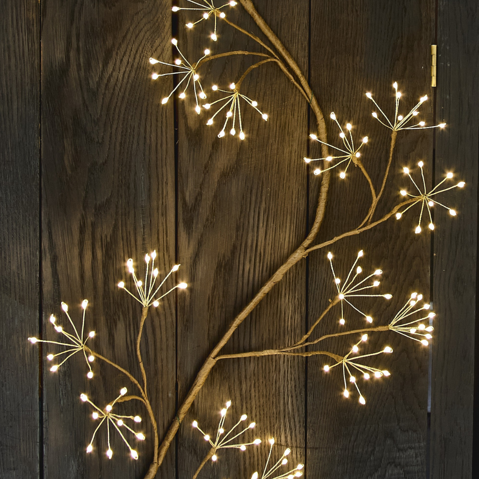 Decorative string lights shaped like branches on a wooden surface