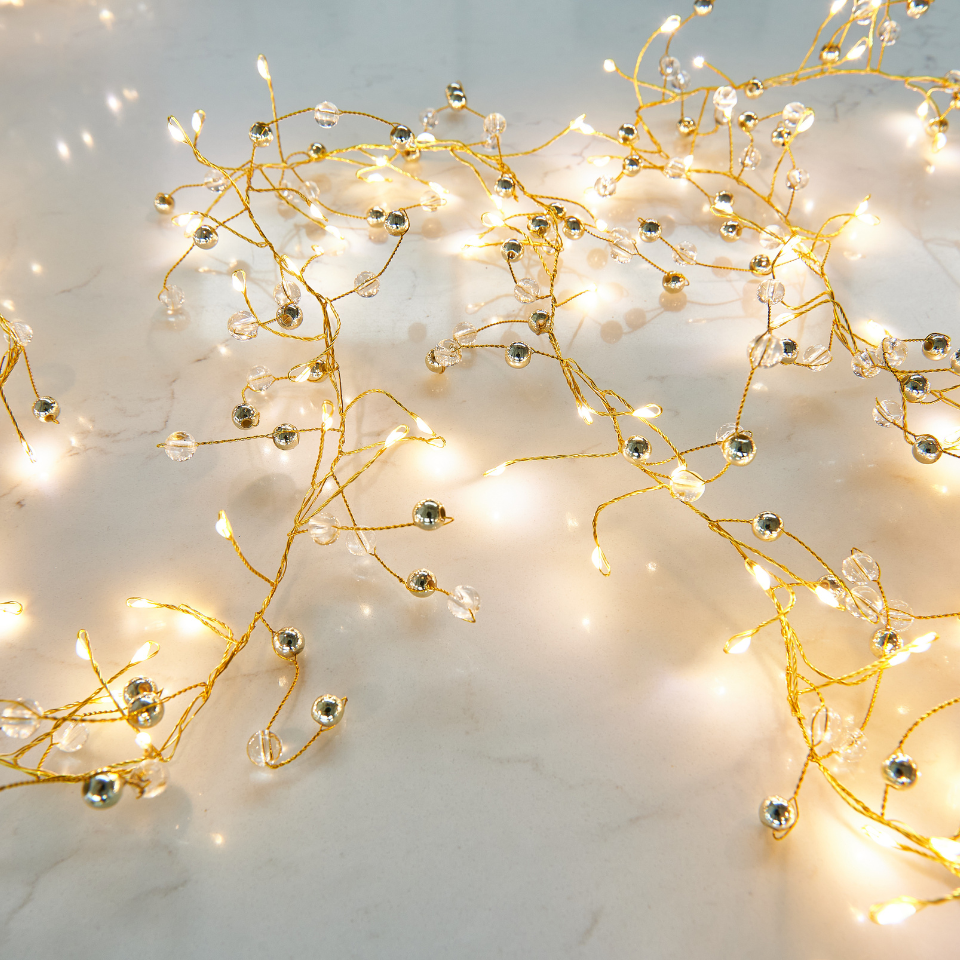 Decorative string lights with beads on a marble surface