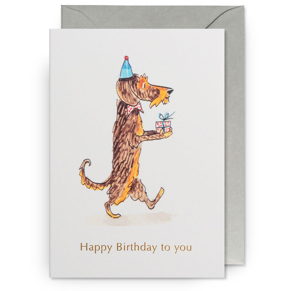 Birthday card with a dog wearing a party hat and holding a gift, with a gray envelope.