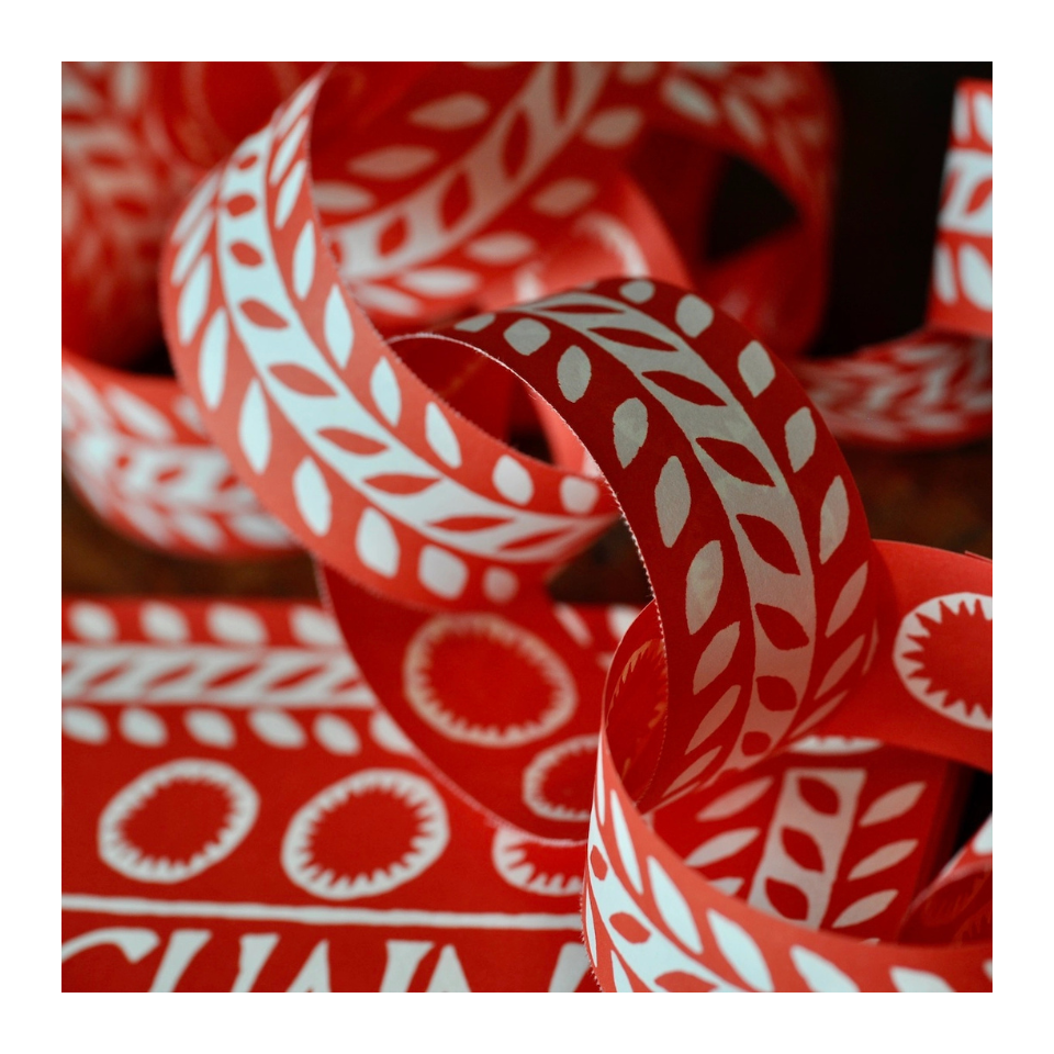 Red paperchain with white patterns on a dark background