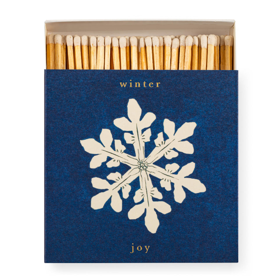 Matchbox with snowflake design and 'winter joy' text on a white background
