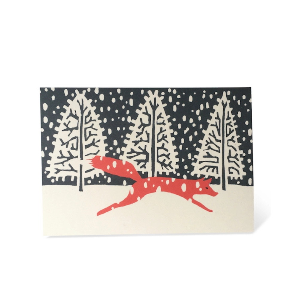Card with a red fox and snowy trees design on a white background