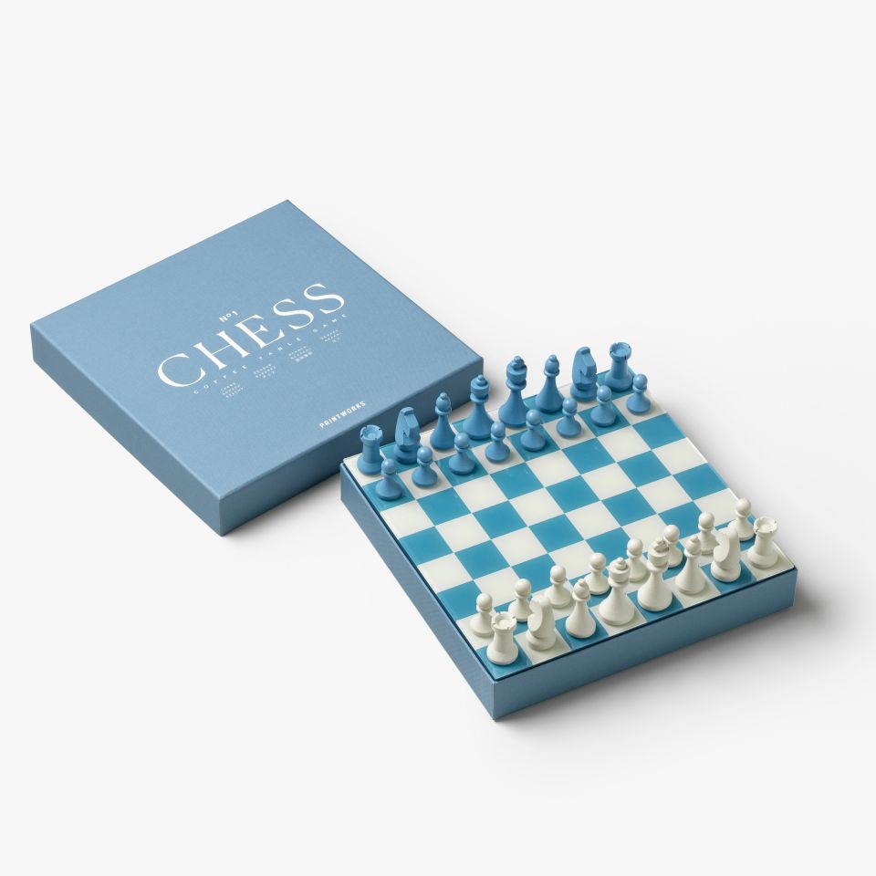 Blue and white chess set with pieces and packaging on a white background