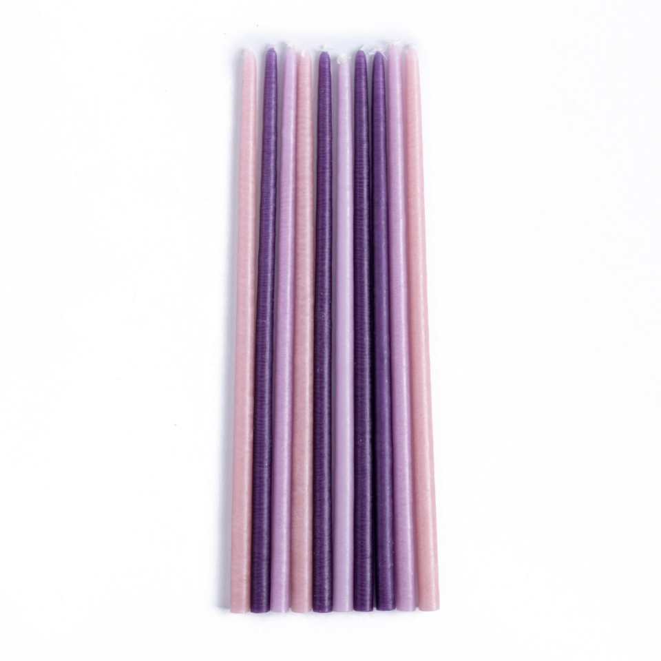 Set of purple and pink candles on a white background