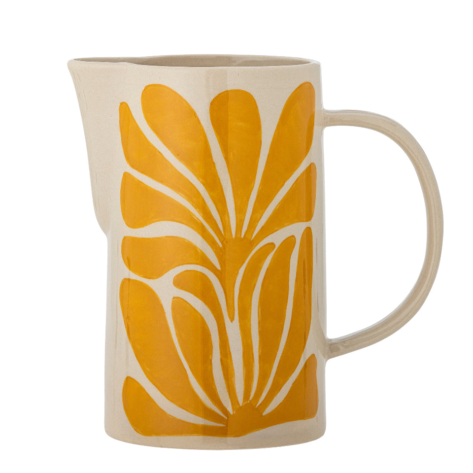 Ceramic pitcher with yellow leaf pattern on a white background