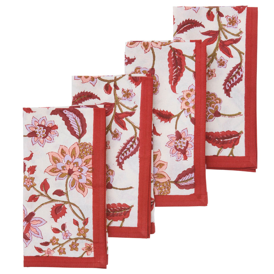 Set of four floral patterned napkins with red borders on a white background