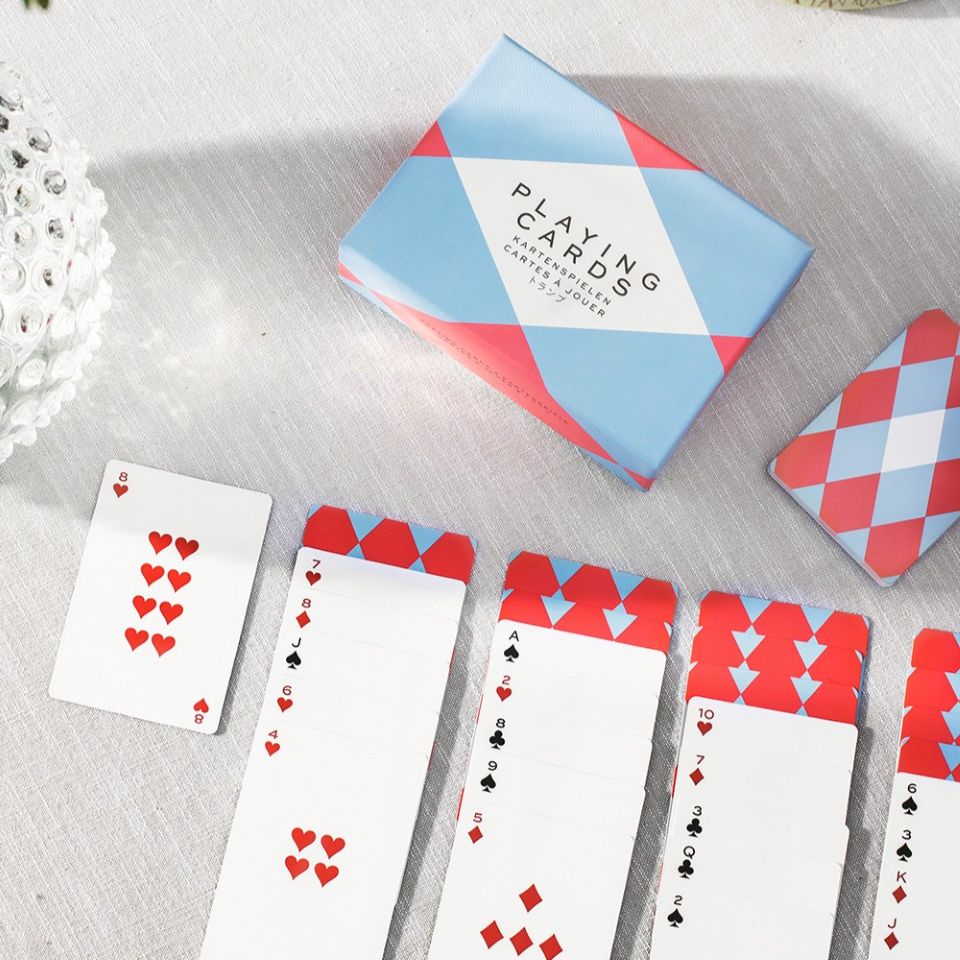 Playing cards with red and blue design on a light gray surface