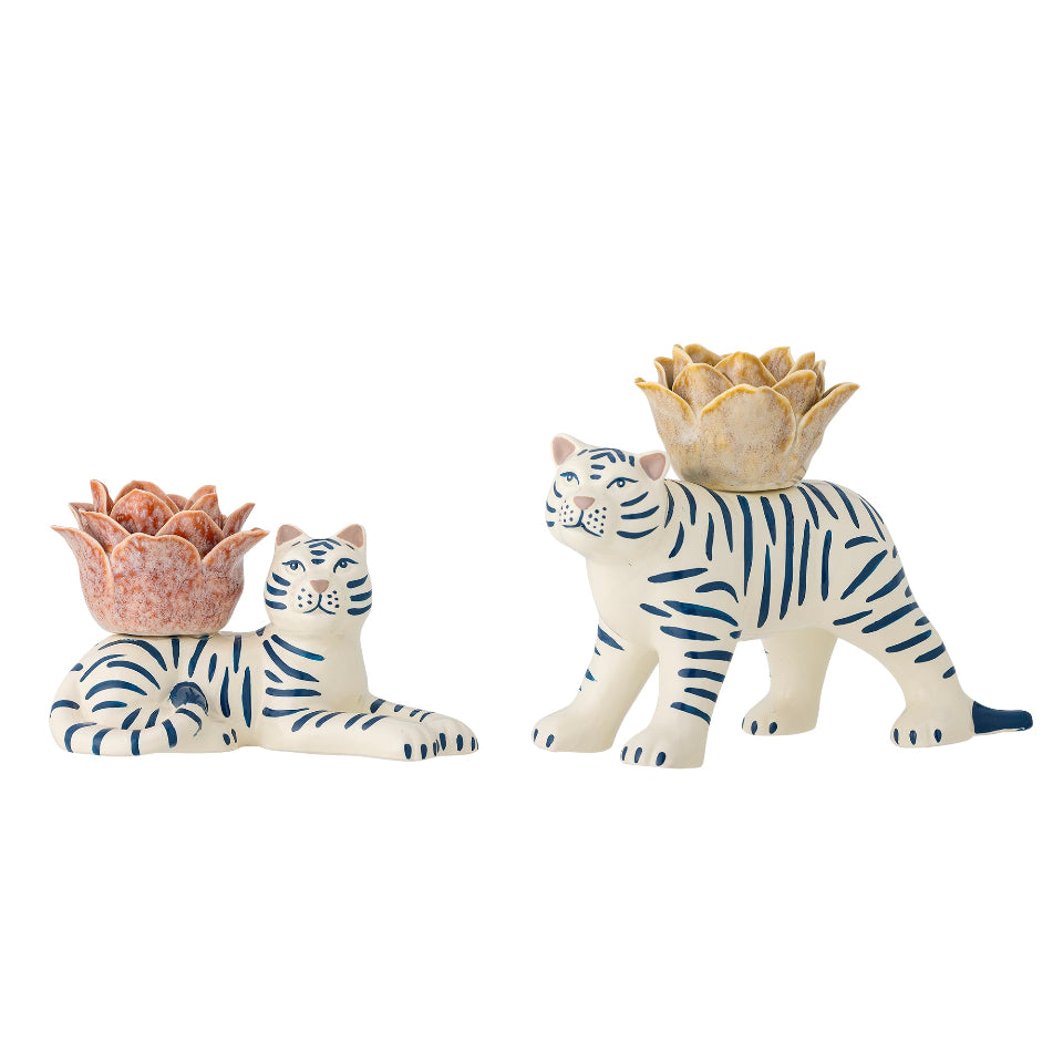 Two ceramic tiger figurines with decorative flower shaped candle holders on the backs on a white background