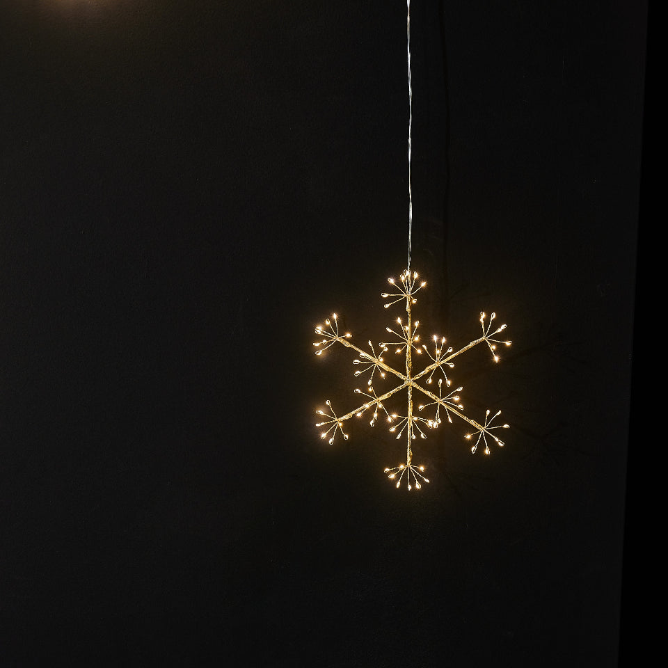 Decorative light in the shape of a snowflake on a black background