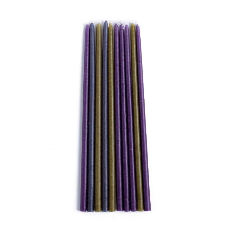 Set of purple and green candles on a white background