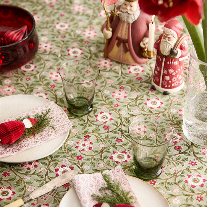 Decorative table setting with floral tablecloth, plates, glasses, and festive decorations.