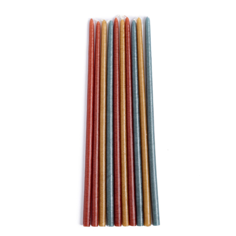 Set of fine candles in shades of rust, green and gold on a white background