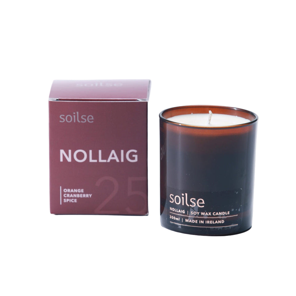 Soy wax candle with 'soilse' branding next to its packaging on a white background