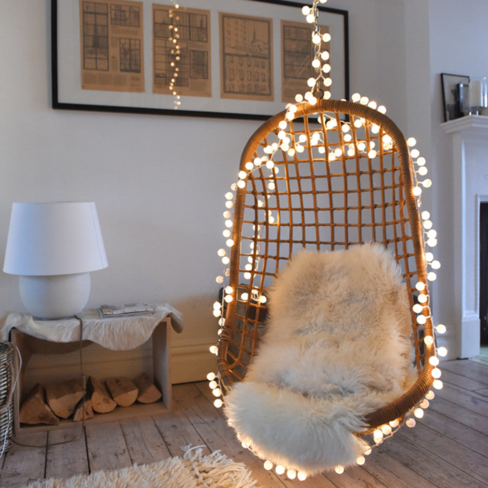 Pom-pom light chain - mains operated, styled on a hanging wicker egg chair.