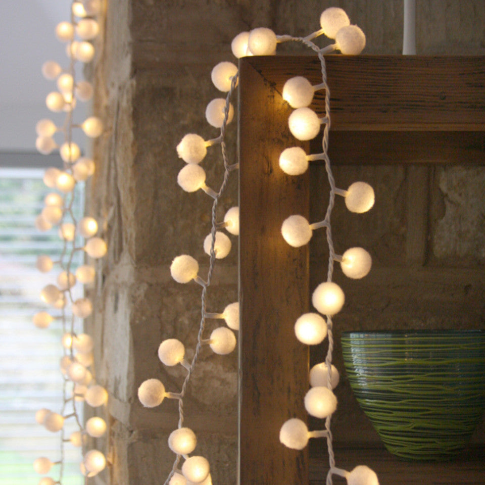 Pom-pom light chain - mains operated, styled draped over a wooden frame.