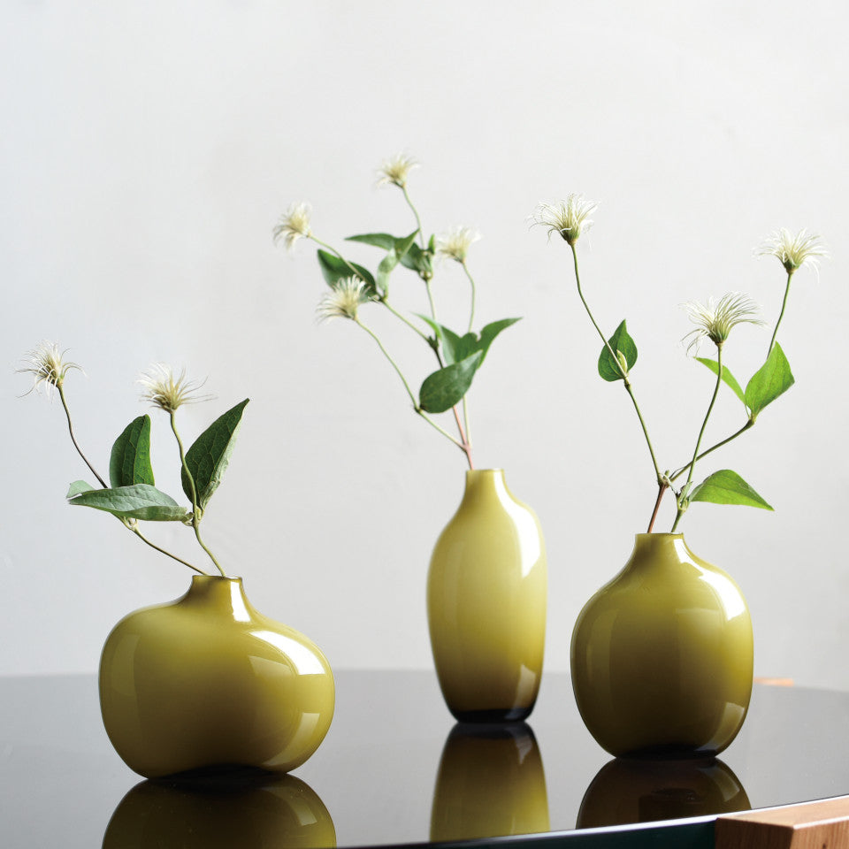 Sacco green glass l-r small, large and medium vases styled with flowers.