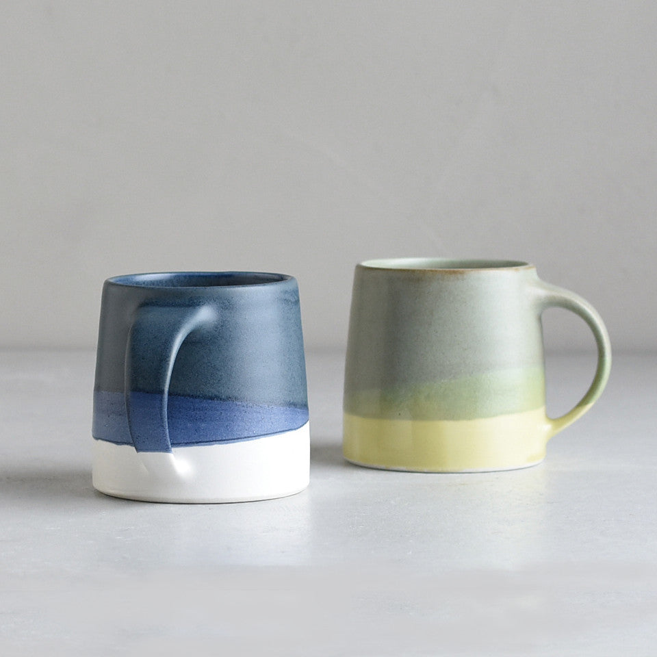SCS (Slow Coffee Style) S03 mugs, l-r: navy / white and moss green / yellow porcelain coffee mug.