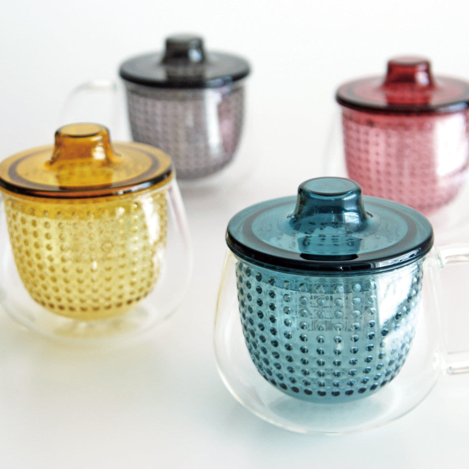 Unimug glass mugs with, l-r, yellow, grey, navy and red strainers and lids, styled